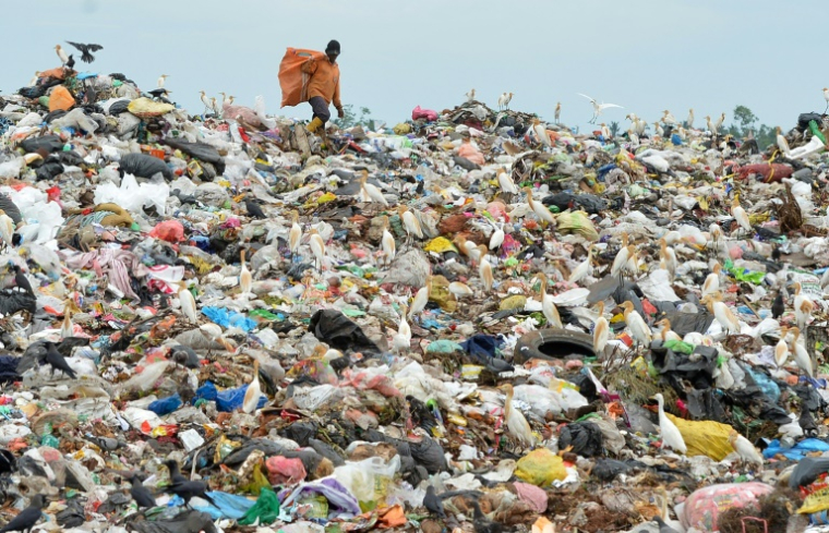 Un ouvrier sri-lankais trie les plastiques dans une décharge proche de Colombo, le 6 mai 2018 ( AFP / LAKRUWAN WANNIARACHCHI )