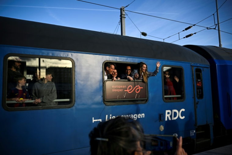Des passagers saluent les journalistes depuis un wagon du premier train de nuit de la ligne Paris-Berlin gérée par la compagnie néerlando-belge European Sleeper, au départ de la Gare du Nord à Paris, le 26 mars 2026 ( AFP / JULIEN DE ROSA )