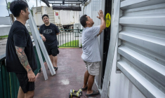 Installation de barricades en métal contre les murs d'un restaurant à l'approche du super typhon Bavi, à Guam, le 5 juillet 2026 ( AFP / Yuichi YAMAZAKI )