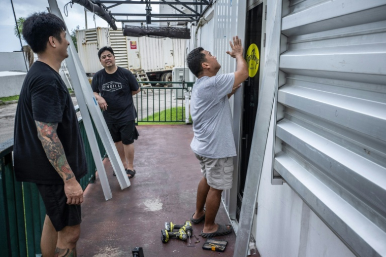 Installation de barricades en métal contre les murs d'un restaurant à l'approche du super typhon Bavi, à Guam, le 5 juillet 2026 ( AFP / Yuichi YAMAZAKI )