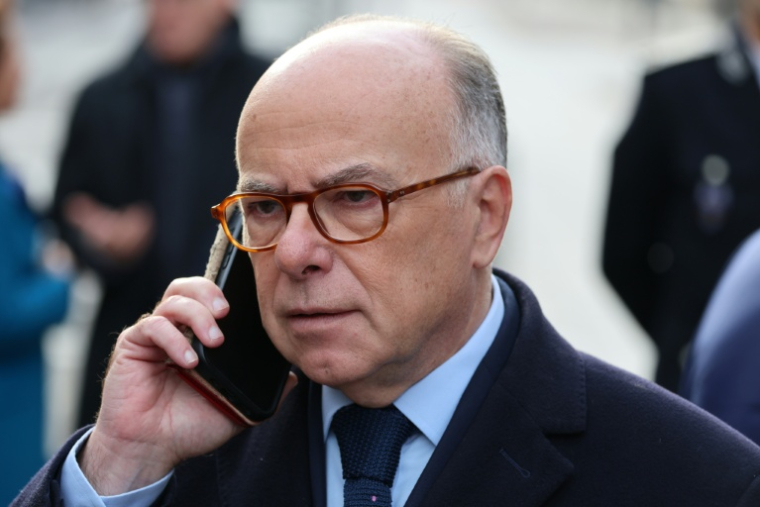 L'ancien Premier ministre Bernard Cazeneuve parle au téléphone avant une cérémonie rendant hommage aux victimes du 13-Novembre devant le Stade de France à Saint-Denis, le 13 novembre 2025 ( POOL / Ludovic MARIN )