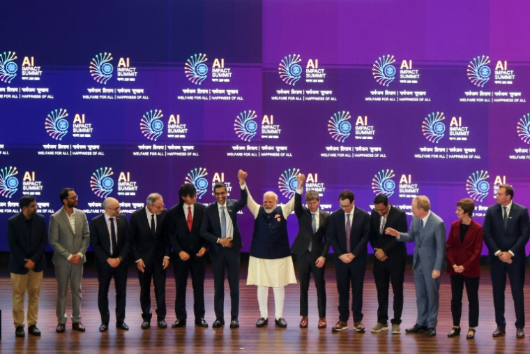 Le Premier ministre indien Narendra Modi (au centre) pose pour une photo de groupe avec les dirigeants d'entreprises spécialisées dans l'intelligence artificielle lors du sommet mondial de l'IA, à New Delhi, le 19 février 2026 ( AFP / Ludovic MARIN )
