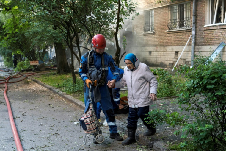 Un secouriste évacue une personne âgée après d'intenses bombardements russes nocturnes qui ont particulièrement visé la capitale ukrainienne, le 24 mai 2026 à Kiev ( AFP / Vladyslav MUSIENKO )