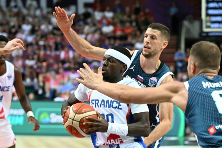Inarrêtable, le meneur de jeu de l'équipe de France Sylvain Francisco résiste aux Slovènes Edo Muric et Gregor Hrovat dans le groupe D de l'Euro à Katowice, le 30 août 2025 ( AFP / Sergei GAPON )