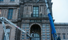 Des ouvriers installent une grille de protection devant la porte-fenêtre de la galerie d'Apollon du Louvre, à Paris, le 23 décembre 2025 ( AFP / Dimitar DILKOFF )