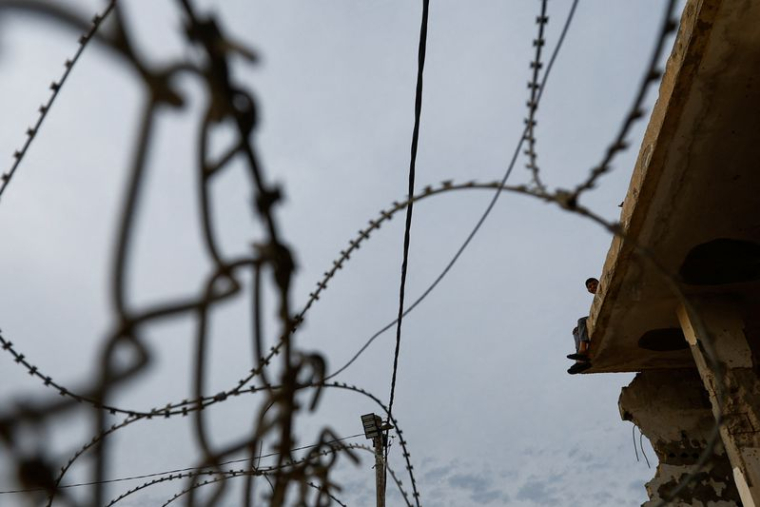 Un enfant est assis sur un bâtiment près de la frontière de Rafah, alors que les militants du Hamas devraient libérer les otages