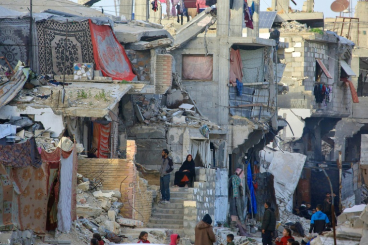 Des Palestiniens au milieu de bâtiments détruits par l'armée israélienne à Khan Younès, dans le sud de la bande de Gaza, le 27 janvier 2026 ( AFP / Bashar Taleb )