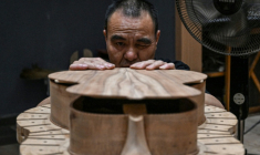 Cette photo prise le 27 juillet 2026 montre un ouvrier fabriquant une guitare dans un atelier de lutherie à Zheng'an, dans la province du Guizhou, dans le sud-ouest de la Chine. ( AFP / Jade GAO )