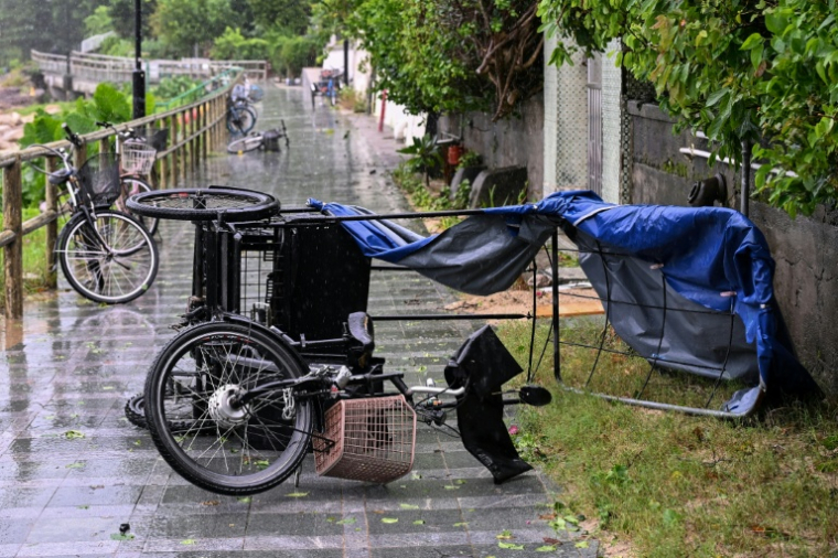 Un pousse-pousse renversé au passage du typhon Noul près de Hong Kong le 26 juillet 2026 ( AFP / Peter PARKS )