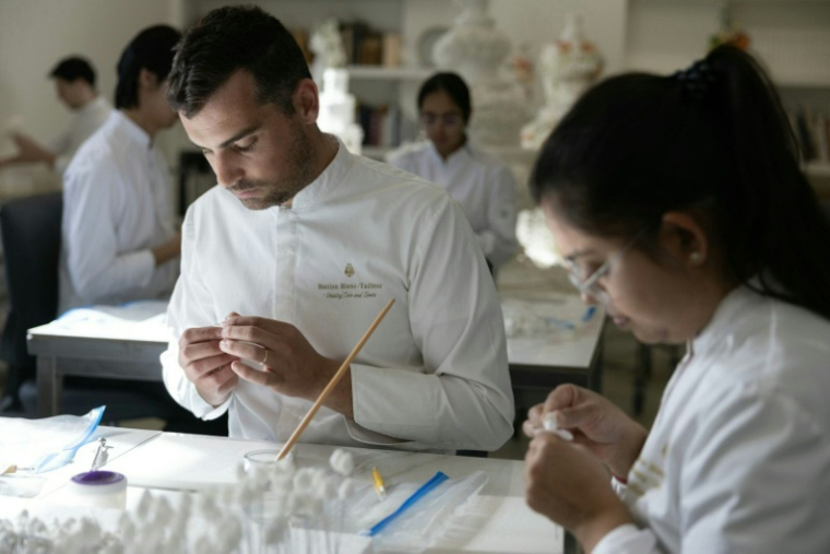 Le chef pâtissier français Bastien Blanc-Tailleur crée des décorations pour un gâteau de mariage dans son atelier de Saint-Rémy-lès-Chevreuse, dans les Yvelines, le 10 avril 2026 ( AFP / Thomas SAMSON )