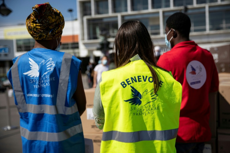 Des bénévoles du Secours populaire distribuent des produits alimentaires et d'hygiène devant l'université Paris 8 à Saint-Denis le 6 mai 2020 ( AFP / Thomas SAMSON )