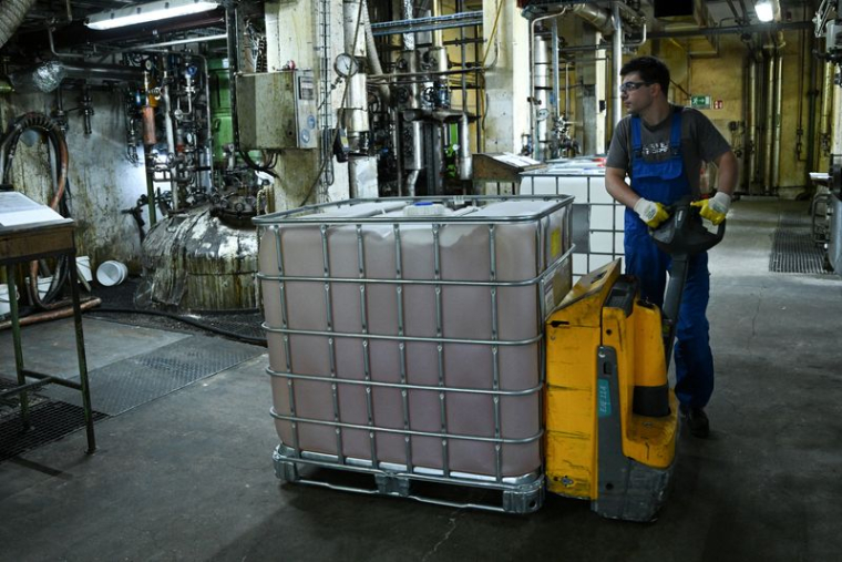 Un travailleur déplace une cuve près des unités de traitement chimique à l'intérieur du hall de production de Hobum Oleochemicals, à Hambourg