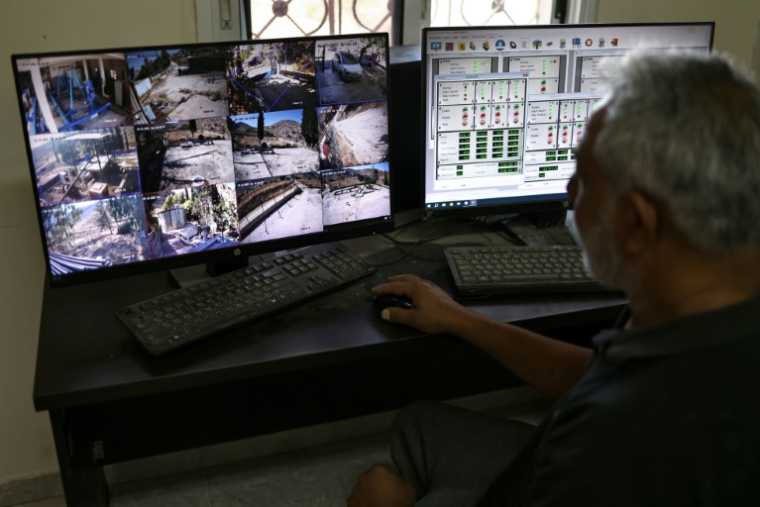 Subhil Olayan vérifie la vidéosurveillance de la station de pompage située près de la source d'Ein Samyah, près du village de Kafr Malik, en Cisjordanie occupée, le 15 juillet 2025 ( AFP / Zain JAAFAR )