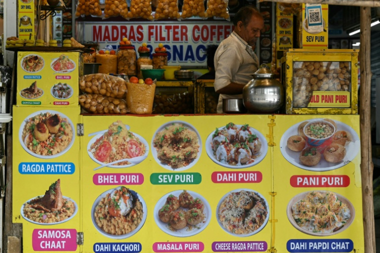 Un vendeur de nourriture prépare ses produits en attendant des clients sur la plage de Juhu, à Bombay, le 6 août 2026 en Inde ( AFP / Indranil MUKHERJEE )