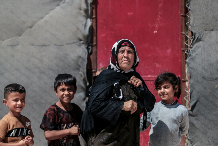 Une femme kurde syrienne déplacée, originaire de la ville de Ras al-Aïn, avec des enfants dans le camp de déplacés d'al-Talaeh, à Hassaké, dans le nord-est de la Syrie, le 23 juillet 2026 ( AFP / Delil SOULEIMAN )