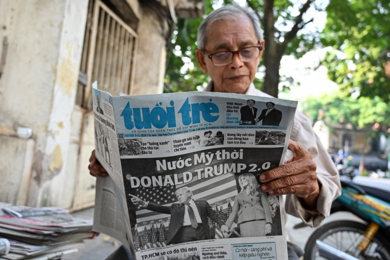 Un Vietnamien lisant le journal au lendemain de la victoire de Donald Trump. (crédit : Nhac NGUYEN / AFP)