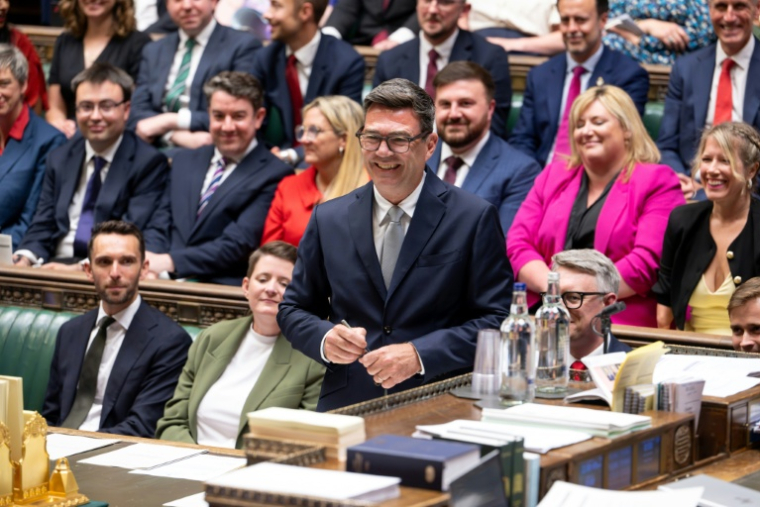 Photo diffusée par le Parlement britannique du nouveau député travailliste de Makerfield, Andy Burnham (c), souriant, après avoir signé le registre à la suite de sa prestation de serment à la Chambre des communes, le 22 mai 2026 à Londres  ( UK PARLIAMENT / - )