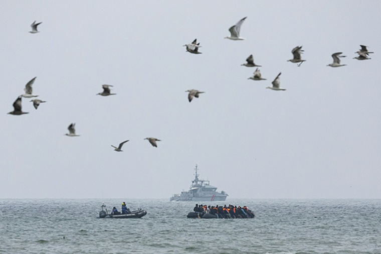 Un bateau de la gendarmerie maritime près d'une embarcation de migrants qui tentent de traverser la Manche au large de la plage de Hardelot, dans le nord de la France, le 13 août 2025 ( AFP / Sameer Al-DOUMY )