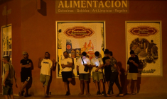 Des jeunes hommes consultent leurs téléphones portables à Torre Pacheco (Espagne), le 15 juillet 2025, alors qu'un rassemblement a été appelé par des groupes d'extrême droite après quatre jours de manifestations et de violences anti-migrants ( AFP / JOSE JORDAN )