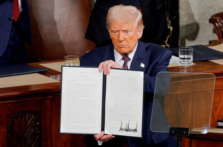 Le président américain Donald Trump tient une copie d'un décret honorant Jocelyn Nungaray lors d'une session conjointe du Congrès, dans la Chambre des représentants du Capitole des États-Unis à Washington