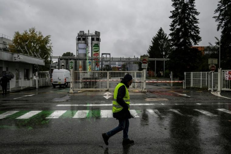 Un employé de Teisseire passe devant l'entrée du site de production du fabricant français de sirops à Crolles, près de Grenoble, dont la fermeture a été annoncée par l'entreprise, en même temps qu'un plan de réorganisation entraînant la suppression de près de 170 emplois, le 20 octobre 2025. ( AFP / JEFF PACHOUD )