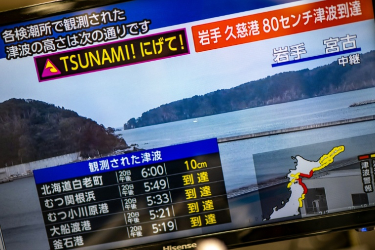 Un message d'alerte sur un écran de la chaîne NHK, signalant un risque de tsunami après un séisme qui a frappé le nord du Japon, le 20 avril 2026 à Tokyo ( AFP / Philip FONG )