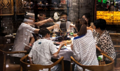 Des convives partagent un repas autour d'une table de « hot pot » chinois dans un restaurant traditionnel de Pékin