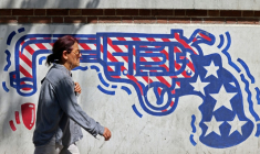 Un passante devant une fresque anti-américaine sur le mur de l'ancienne ambassade américaine à Téhéran, le 11 avril 2026 ( AFP / ATTA KENARE )