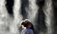 Une femme se rafraîchit sous un brumisateur à l'occasion de la Fête de la Musique à Bordeaux, en Gironde, pendant un épisode de canicule en France, le 21 juin 2026 ( AFP / ROMAIN PERROCHEAU )