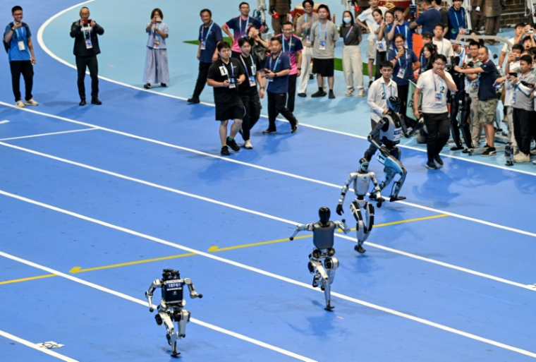 Des robots s'affrontent sur un 100 mètres durant la cérémonie d'ouverture de la première compétition mondiale de robots humanoïdes à Pékin, le 14 août 2025 ( AFP / ADEK BERRY )