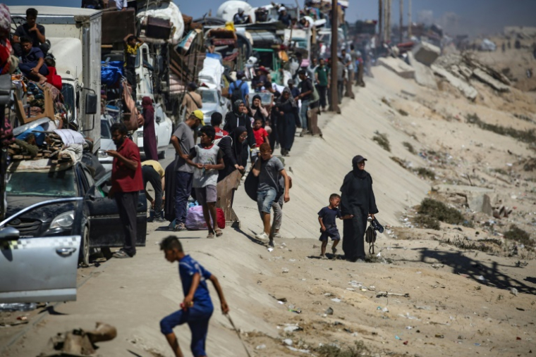 Des Palestiniens de la ville de Gaza se déplacent vers le sud de la bande de Gaza avec leurs affaires, sur la route côtière près du camp de réfugiés de Nousseirat dans le centre du territoire, pour fuir une opération militaire israélienne, le 19 septembre 2025 ( AFP / Eyad BABA )