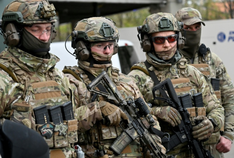 Des agents des forces spéciales de la police devant un supermarché à la suite d'une fusillade survenue à Kiev le 18 avril 2026 ( AFP / Sergei SUPINSKY )