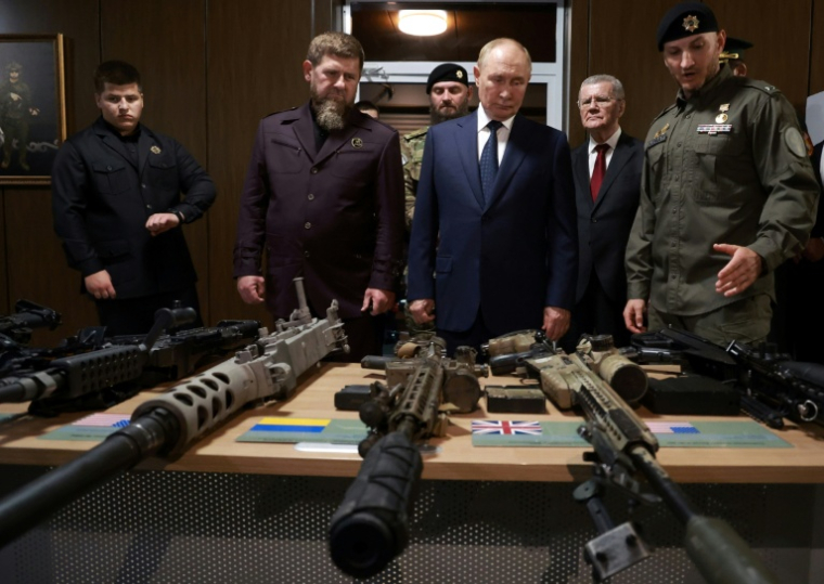 Le président russe Vladimir Poutine observe des armes à feu aux côtés du dirigeant tchétchène Ramzan Kadyriv, le 21 août 2024 à Goudermes, en Tchétchénie ( POOL / Vyacheslav PROKOFYEV )
