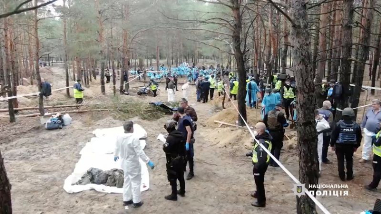 Le personnel médico-légal travaille sur un site d'enterrement collectif près de la ville d'Izium, en Ukraine