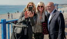 Le nouveau maire de Nice UDR Eric Ciotti, à droite, pose pour une photo avec des passantes sur la Promenade des Anglais à Nice le 23 mars 2026 ( AFP / Valery HACHE )