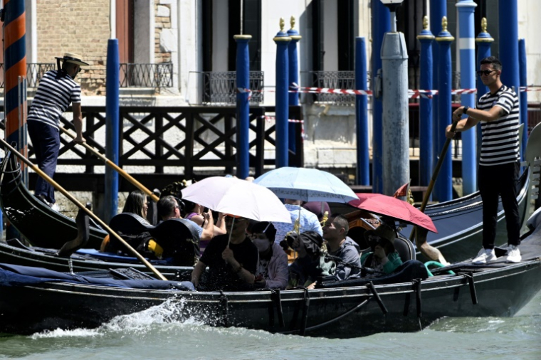 Des touristes en gondole sur la lagune de Venise, le jour du mariage de Jeff Bezos et Lauren Sanchez, le 27 juin 2025 ( AFP / ANDREA PATTARO )
