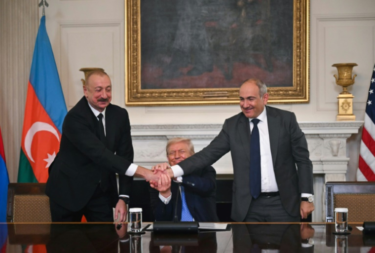 Le président azerbaïdjanais Ilham Aliev (à gauche) et le Premier ministre arménien Nikol Pachinian (à droite) se serrent la main en présence du président américain Donald Trump, le 8 août 2025 à la Maison Blanche ( AFP / ANDREW CABALLERO-REYNOLDS )