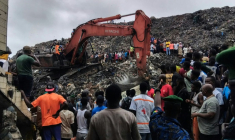 Une pelleteuse est utilisée pour rechercher des corps, après l'effondrement d'une décharge sur des habitations à Dar es salam dans la banlieue de Conakry, le 23 août 2026  ( AFP / - )