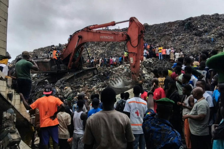 Une pelleteuse est utilisée pour rechercher des corps, après l'effondrement d'une décharge sur des habitations à Dar es salam dans la banlieue de Conakry, le 23 août 2026  ( AFP / - )