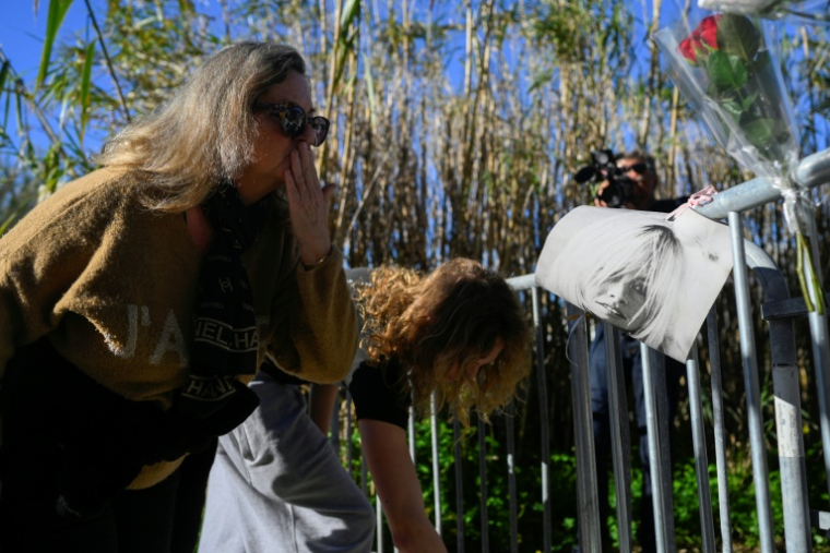 Une femme adresse un baiser à un portrait de Brigitte Bardot devant la propriété de la star décédée, le 28 décembre 2025 à Saint-Tropez ( AFP / Frederic DIDES )