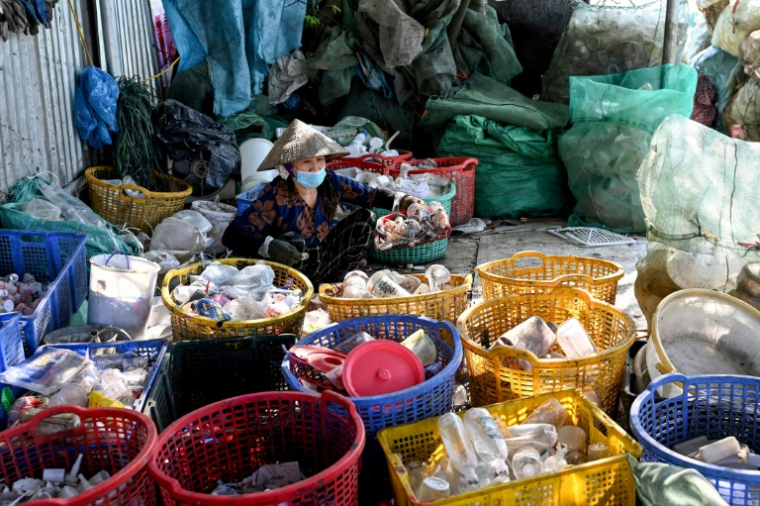 Une femme trie des déchets n plastique près de Hanoï, au Vietnam, le 25 novembre 2025 ( AFP / Nhac NGUYEN )