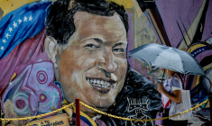 Une femme se protégeant du soleil avec un parapluie arrive au mausolée de l'ancien président vénézuélien Hugo Chavez à Caracas, le 5 mars 2026 ( AFP / Juan BARRETO )