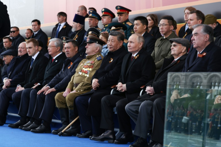 Photo diffusée par l'agence d'état russe Sputnik, du président russe Vladimir Poutine, du président chinois Xi Jinping et d'autres dirigeants étrangers assistant au défilé militaire du Jour de la Victoire sur la Place Rouge,à Moscou, le 9 mai 2025 ( POOL / Vyacheslav PROKOFYEV )