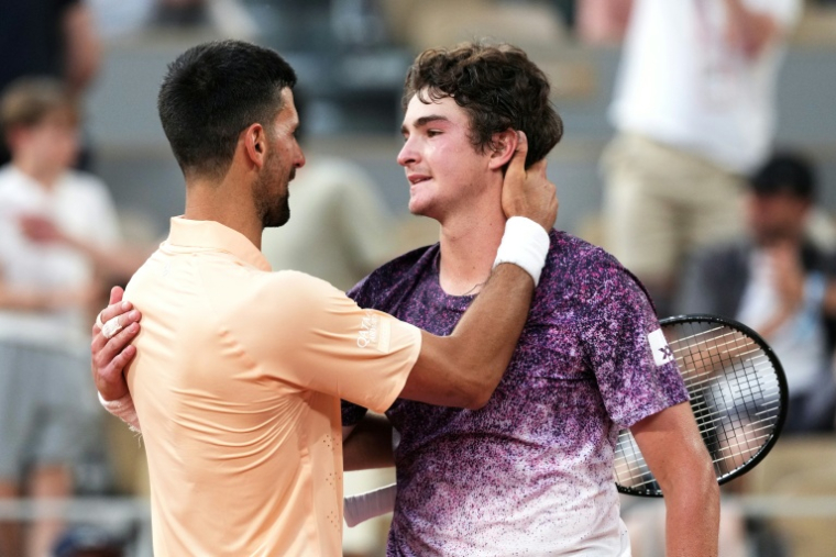 Novak Djokovic salue le Brésilien Joao Fonseca, tombeur du Serbe à Roland-Garros, le 29 mai 2026 ( AFP / Dimitar DILKOFF )