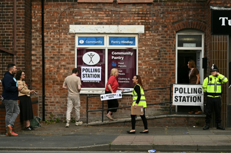 Des électeurs arrivent pour voter à l'élection partielle de Makerfield, dans le nord-ouest de l'Angleterre, dans un bureau de vote installé dans un centre communautaire à Hindley, le 18 juin 2026 ( AFP / Oli SCARFF )