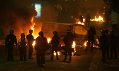 Des policiers devant des véhicules incendiés, le 28 octobre 2005 à Clichy-sous-Bois, en Seine-Saint-Denis, où de nouvelles violences urbaines ont éclaté entre des jeunes des quartiers difficiles et les forces de l'ordre ( AFP / Joël SAGET )