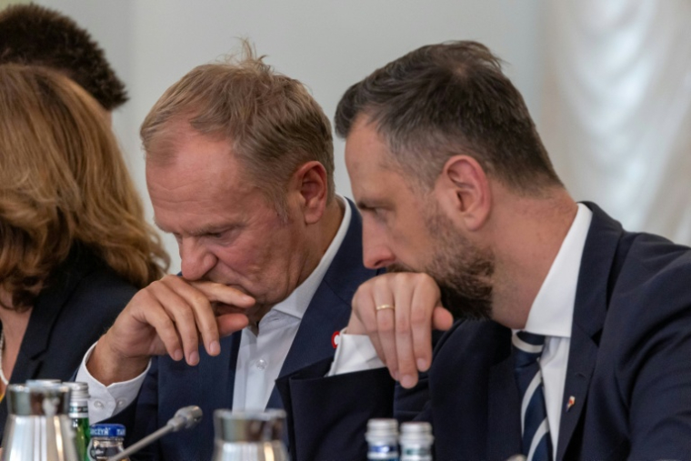 Le Premier ministre polonais Donald Tusk (à gauche) et le ministre de la Défense Wladyslaw Kosiniak-Kamysz (à droite) discutent avant une réunion du Conseil national de sécurité liée à l'intrusion de drones présumés russes en Pologne, le 11 septembre 2025 à Varsovie ( AFP / Wojtek RADWANSKI )