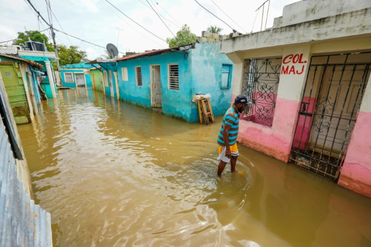 Un homme marche dans une rue inondée à Saint-Domingue, en République dominicaine, le 29 octobre 2025 ( AFP / Danny Polanco )