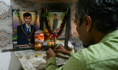 Suresh Patni, père d'Akash Patni, victime du crash du vol 171 d'Air India d'Air India, prie devant les portraits de son fils à son domicile d'Ahmedabad, le 8 novembre 2025 en Inde ( AFP / Indranil MUKHERJEE )