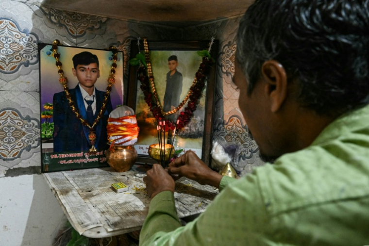 Suresh Patni, père d'Akash Patni, victime du crash du vol 171 d'Air India d'Air India, prie devant les portraits de son fils à son domicile d'Ahmedabad, le 8 novembre 2025 en Inde ( AFP / Indranil MUKHERJEE )